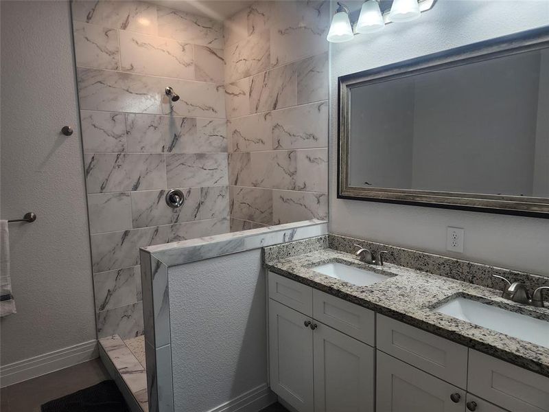 Bathroom featuring vanity and tiled shower