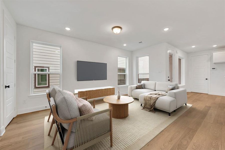 Open-concept living space featuring wood-finish flooring, recessed lighting, and white trim throughout