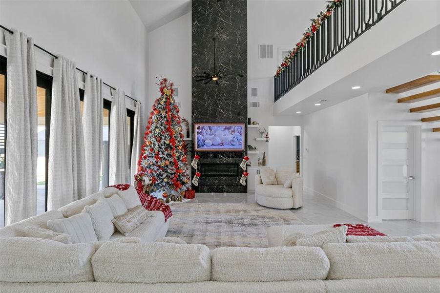 Living room with a high ceiling, stairway, and recessed lighting Living room with a high ceiling, stairway, and recessed lighting