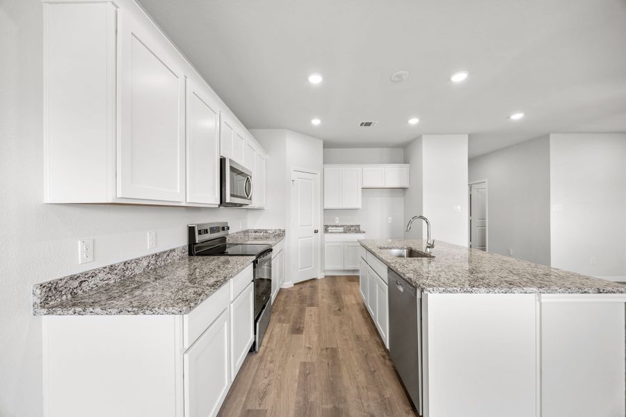 A kitchen with white cabinets.