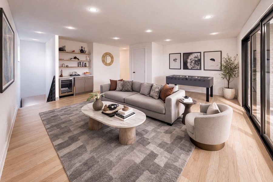 Perfect for gathering and relaxing, the spacious third-floor game room features a dry bar with beverage refrigerator and opens to a covered balcony with an outdoor fireplace
