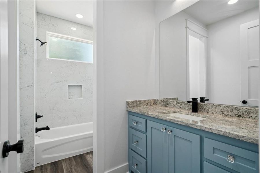 Bathroom with vanity, wood finished floors, shower / tub combination, and recessed lighting