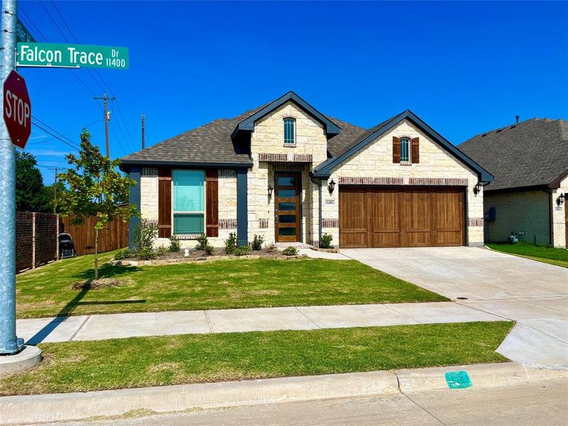 View of front of home with a garage and a front lawn