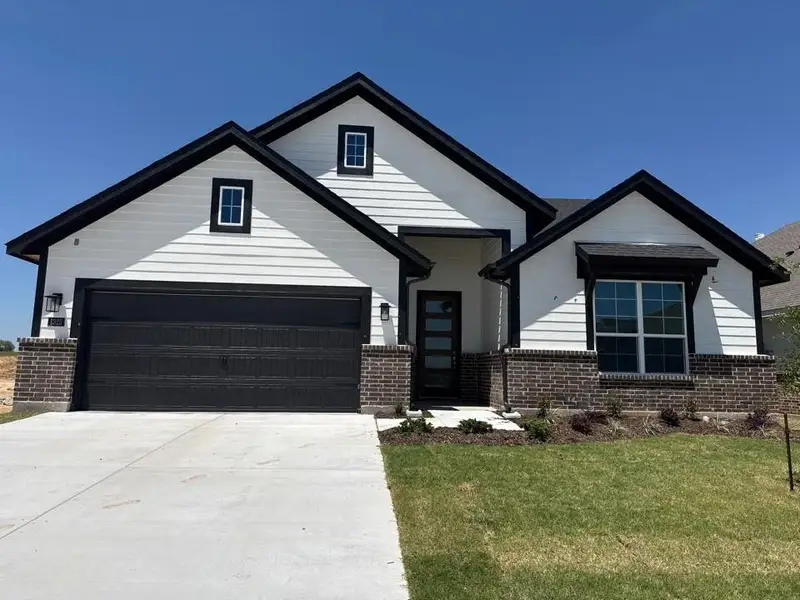 Front exterior of a new home in Covenant Park, Springtown, TX, highlighting curb appeal (Image 1). Front exterior of a new home in Covenant Park, Springtown, TX, highlighting curb appeal (Image 1).