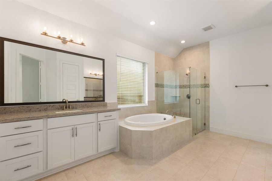 This primary bathroom is definitely move-in ready! Featuring a frameless walk-in shower with tile surround, separate garden tub for soaking after a long day with custom tile detailing, bright white cabinets with granite countertops, spacious walk-in closet with shelving, high ceilings, sleek and modern finishes.