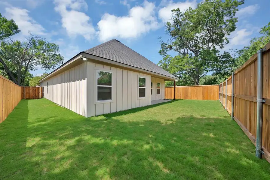 Manicured lawn surrounding a board and batten exterior with multiple windows Manicured lawn surrounding a board and batten exterior with multiple windows