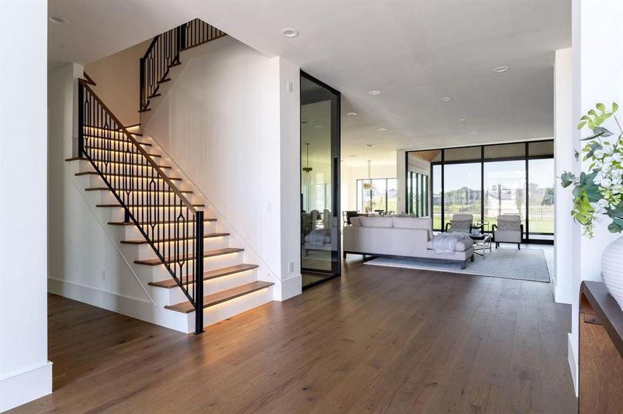 Stairway featuring a wall of windows and hardwood / wood-style floors