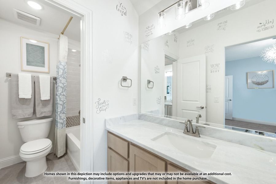 Bathroom with marble countertop vanity, large mirror, toilet, and tub-shower combo with decorative curtain Bathroom with marble countertop vanity, large mirror, toilet, and tub-shower combo with decorative curtain