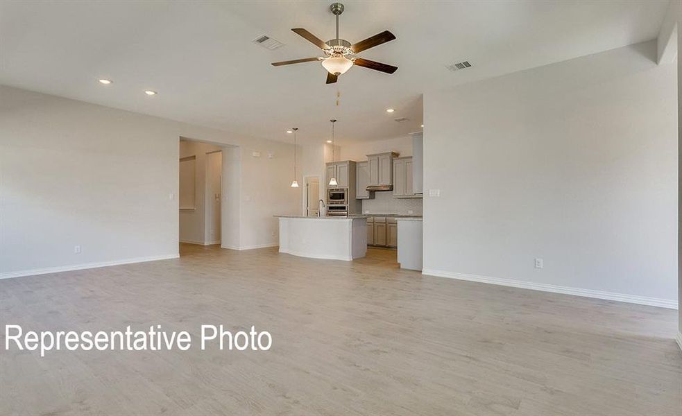 Spacious interior featuring wood-finish flooring, recessed lighting, and a ceiling fan