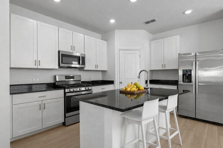 Kitchen counter is ready to have guests pull up a chair and watch the chef