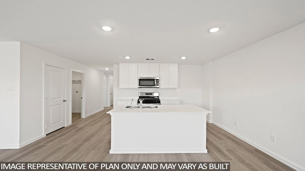 Kitchen featuring a center island with sink, white cabinets, light wood-type flooring, stainless steel appliances, and recessed lighting
