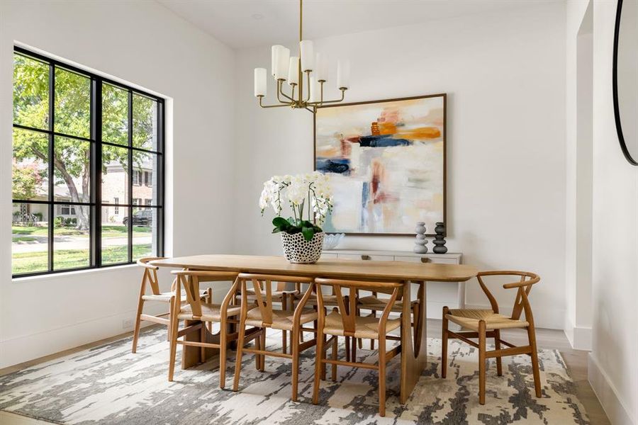 Dining room with wood finished floors and a chandelier Dining room with wood finished floors and a chandelier