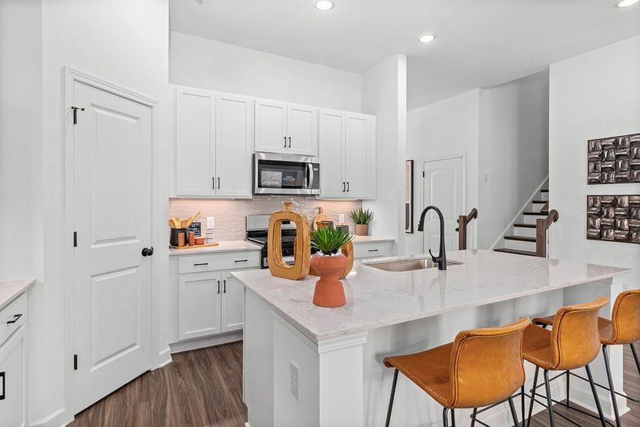 A kitchen with white cabinets.