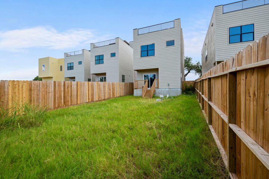 Rear view of property with a fenced backyard and entry steps