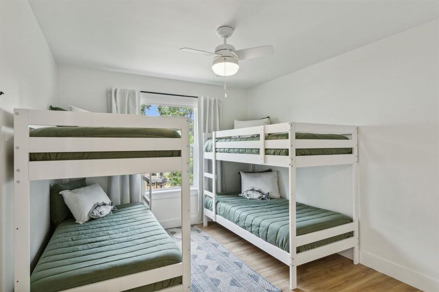 Bedroom featuring hardwood / wood-style floors, ceiling fan, and multiple windows