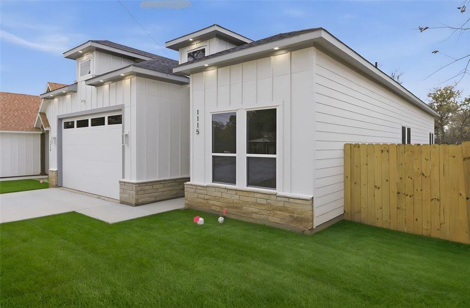 View of front of home featuring board and batten siding, stone siding, a shingled roof, driveway, and an attached garage