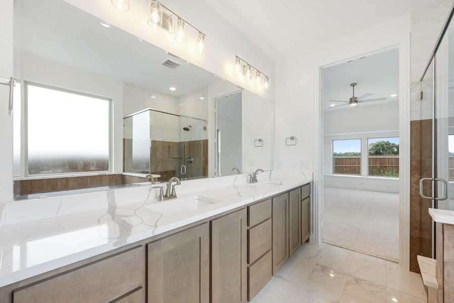 Master bathroom with double vanity, quartz countertops, glass shower, and tile floors Master bathroom with double vanity, quartz countertops, glass shower, and tile floors