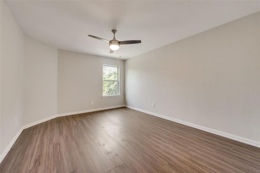 Unfurnished room with dark hardwood / wood-style floors and ceiling fan