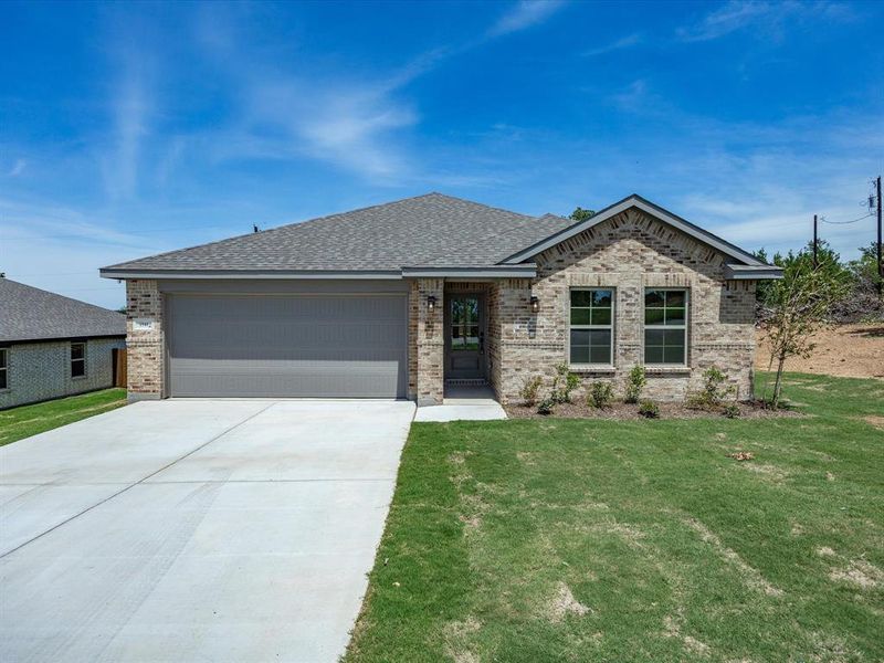 Brick facade residence featuring a two-car garage, grey shingles, and a concrete driveway Brick facade residence featuring a two-car garage, grey shingles, and a concrete driveway