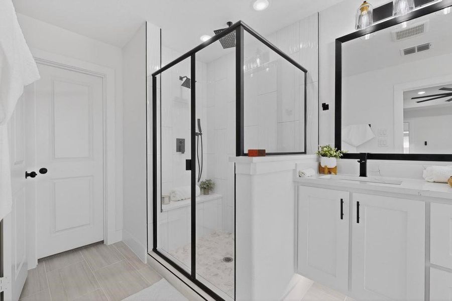 Primary bathroom featuring vanity, a marble finish shower, and recessed lighting Primary bathroom featuring vanity, a marble finish shower, and recessed lighting
