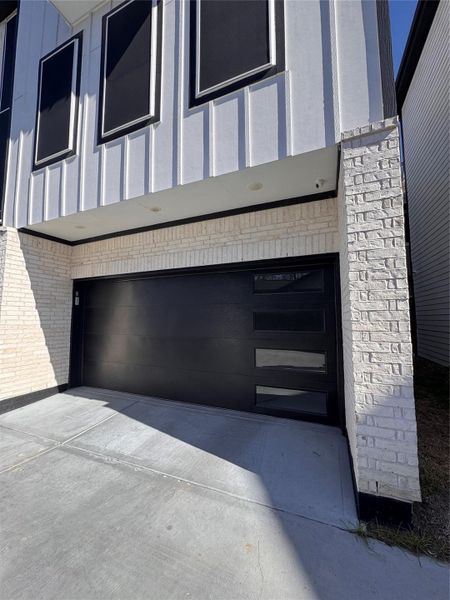 Sleek and modern, this home features a black garage door framed by white brick, offering a striking contrast and contemporary curb appeal. Sleek and modern, this home features a black garage door framed by white brick, offering a striking contrast and contemporary curb appeal.