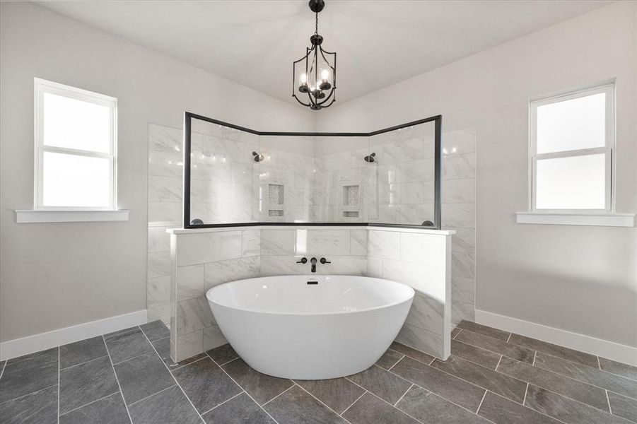 Bathroom featuring shower with separate bathtub, a chandelier, and tile patterned floors