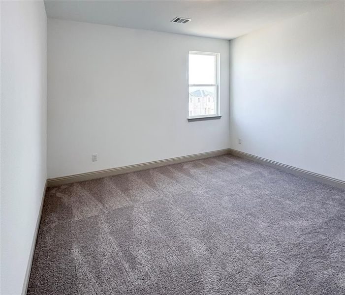 Carpeted empty room featuring visible vents and baseboards