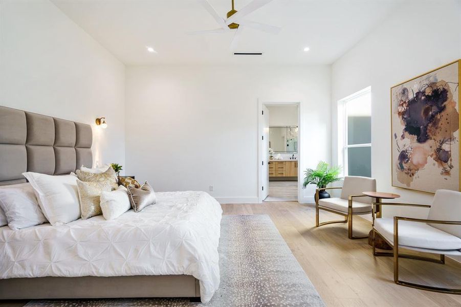 Bedroom featuring ensuite bathroom, ceiling fan, and light wood-type flooring