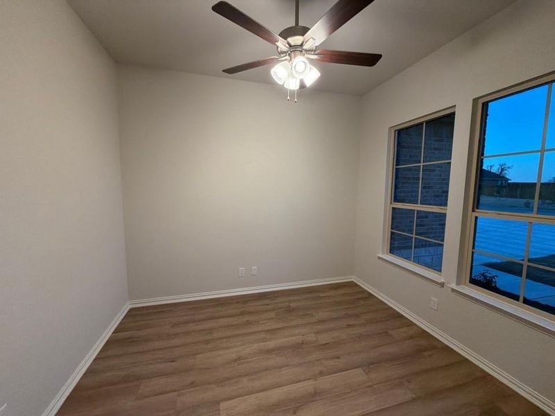 Spare room featuring wood finished floors and a ceiling fan
