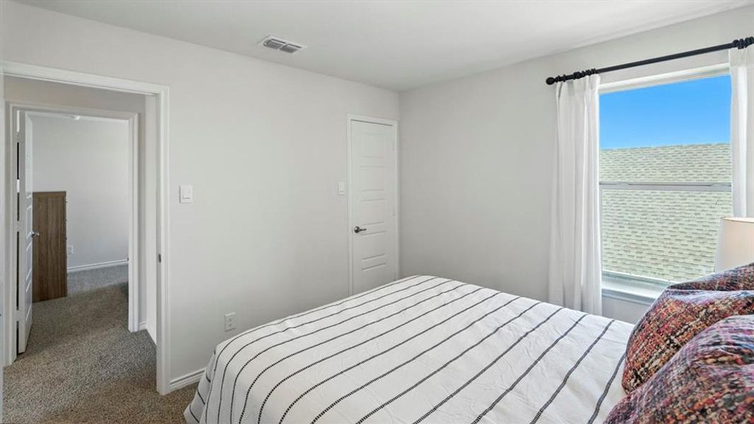 Bedroom featuring dark colored carpet and baseboards