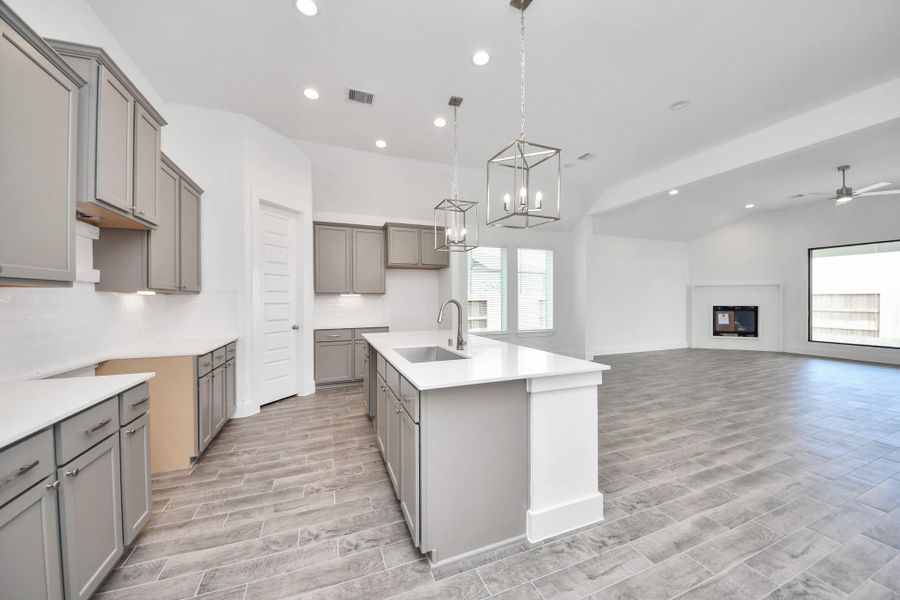 Step into a dream realized with this generously spacious kitchen! A massive granite island takes center stage, complemented by high ceilings and soft-close cabinets. The granite countertops, stainless steel appliances, sleek tile backsplash, and recessed lighting complete the elegant design.