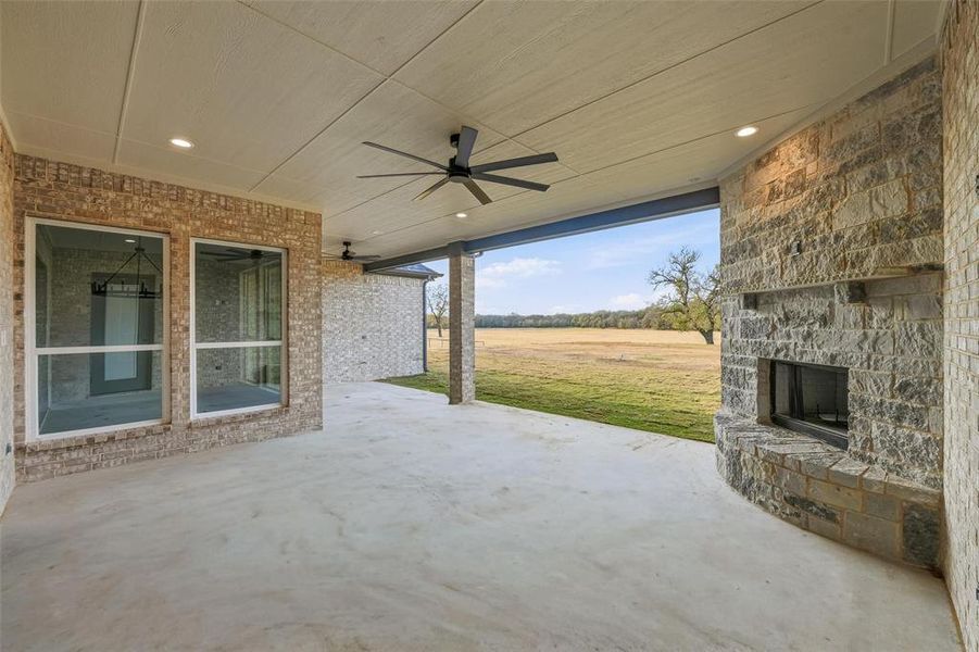 View of patio / terrace with a ceiling fan and an outdoor stone fireplace View of patio / terrace with a ceiling fan and an outdoor stone fireplace