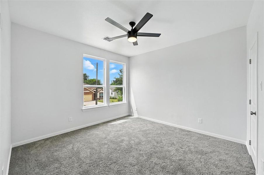 Carpeted spare room with baseboards and ceiling fan