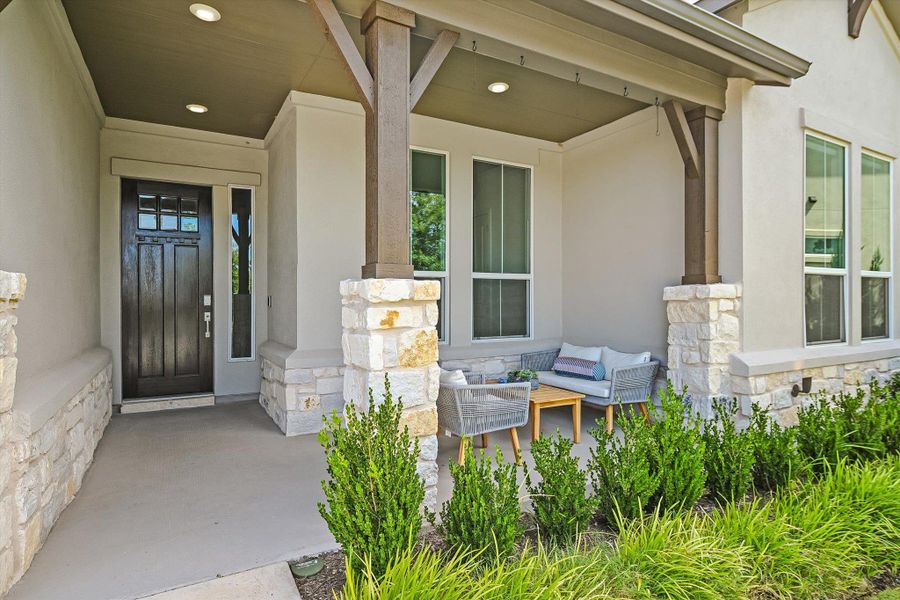 View of exterior entry with stone siding, stucco siding, and covered porch View of exterior entry with stone siding, stucco siding, and covered porch
