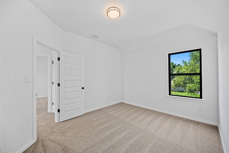 Spare room featuring carpet, lofted ceiling, and baseboards Spare room featuring carpet, lofted ceiling, and baseboards