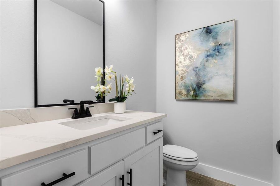 Bathroom featuring hardwood / wood-style flooring, vanity, and toilet