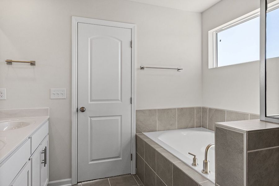 A bathroom with a tub and sink. A bathroom with a tub and sink.