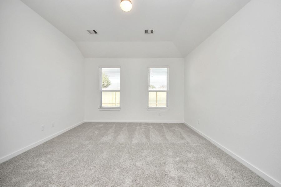 Come and unwind after a long day in this magnificent primary suite! This spacious room features plush carpet, warm paint, high ceilings and large windows with privacy blinds. Sample photo of completed home with similar floor plan. Actual colors and selections may vary.