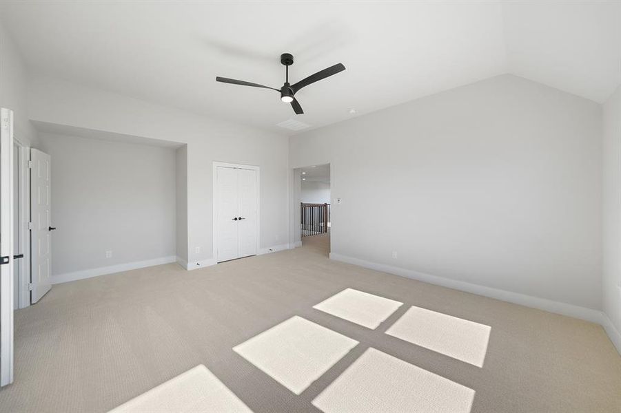 Unfurnished bedroom featuring light carpet, a ceiling fan, lofted ceiling, and a closet Unfurnished bedroom featuring light carpet, a ceiling fan, lofted ceiling, and a closet
