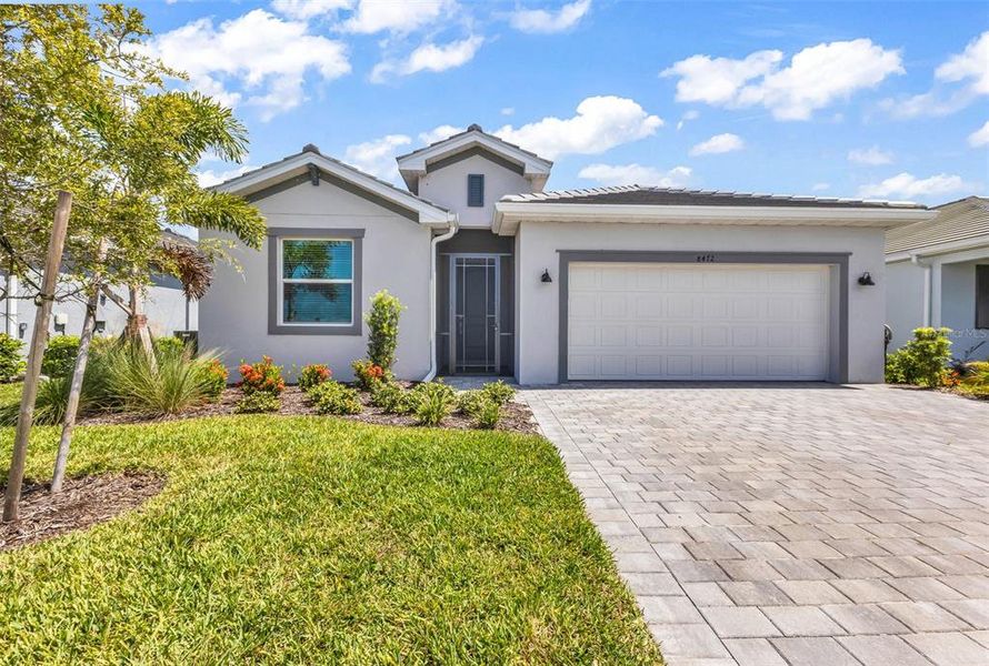 Front exterior of a new home in Palm Lake at Coco Bay, Englewood, FL, highlighting curb appeal (Image 1). Front exterior of a new home in Palm Lake at Coco Bay, Englewood, FL, highlighting curb appeal (Image 1).