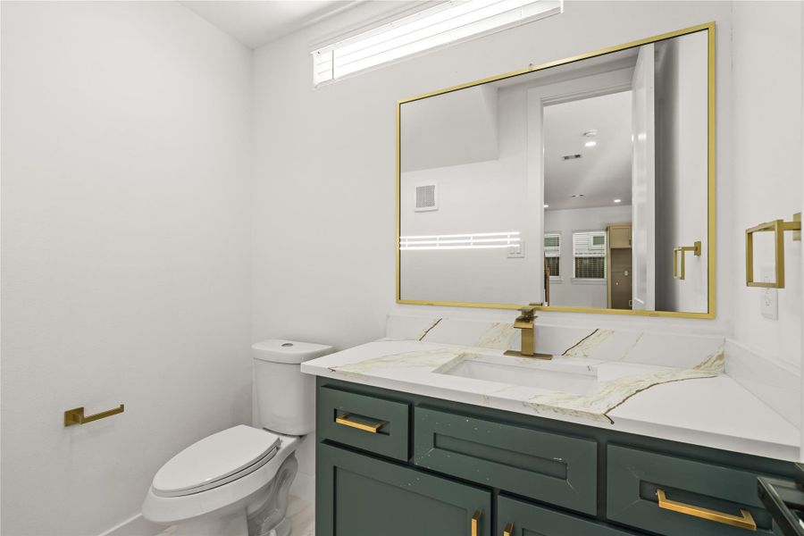 A memorable guest experience. High-end accents, an oversized gold-trimmed mirror, and brilliant lighting make this compact space feel incredibly luxurious.
