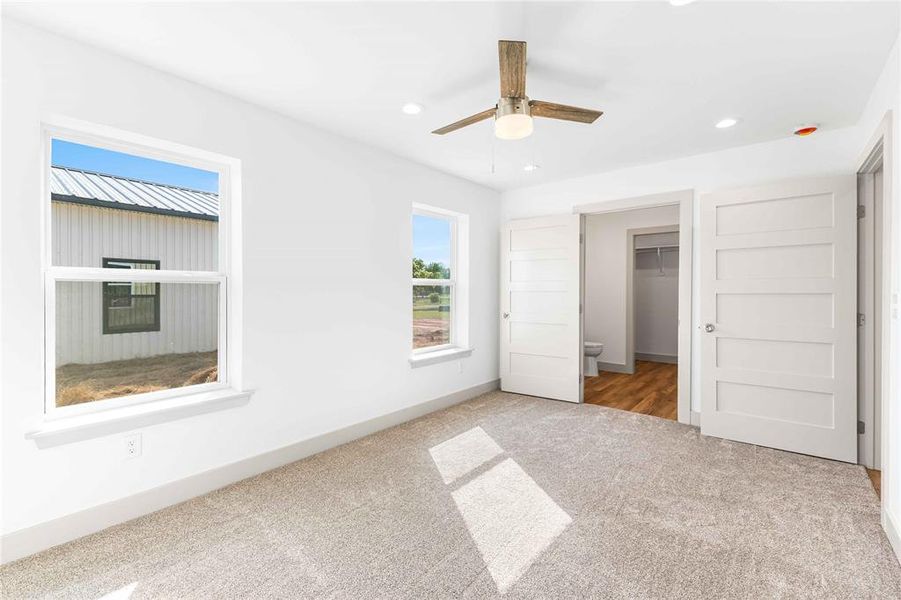 Unfurnished bedroom with carpet, recessed lighting, a walk in closet, ceiling fan, and a closet Unfurnished bedroom with carpet, recessed lighting, a walk in closet, ceiling fan, and a closet