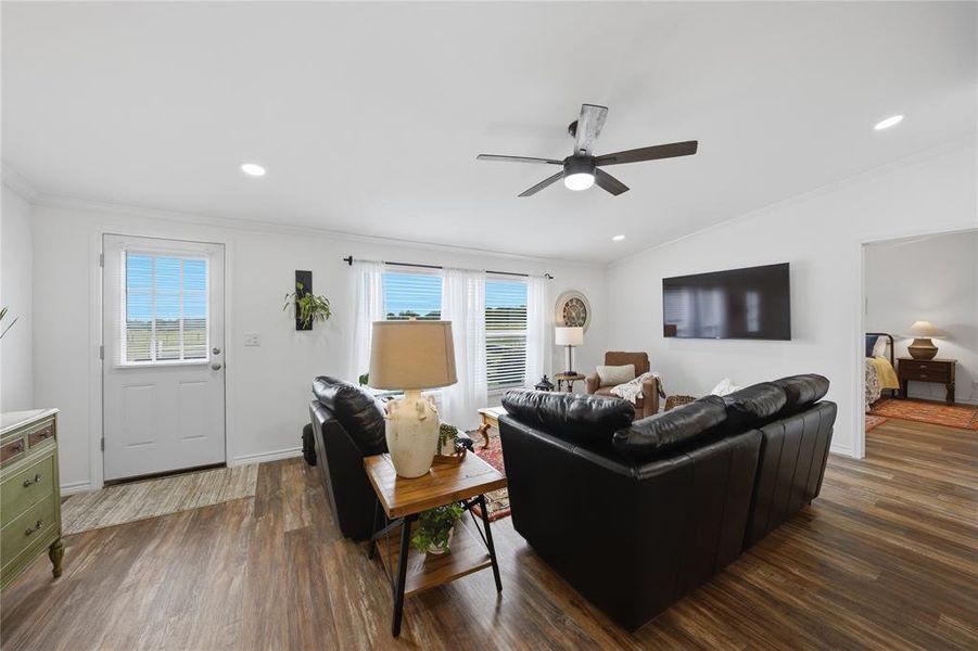 Open concept living space featuring wood-finish flooring and a ceiling fan