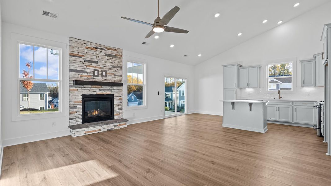 Highly skilled craftsmanship and modern elegance meet in this family room with soaring ceilings and stone fireplace