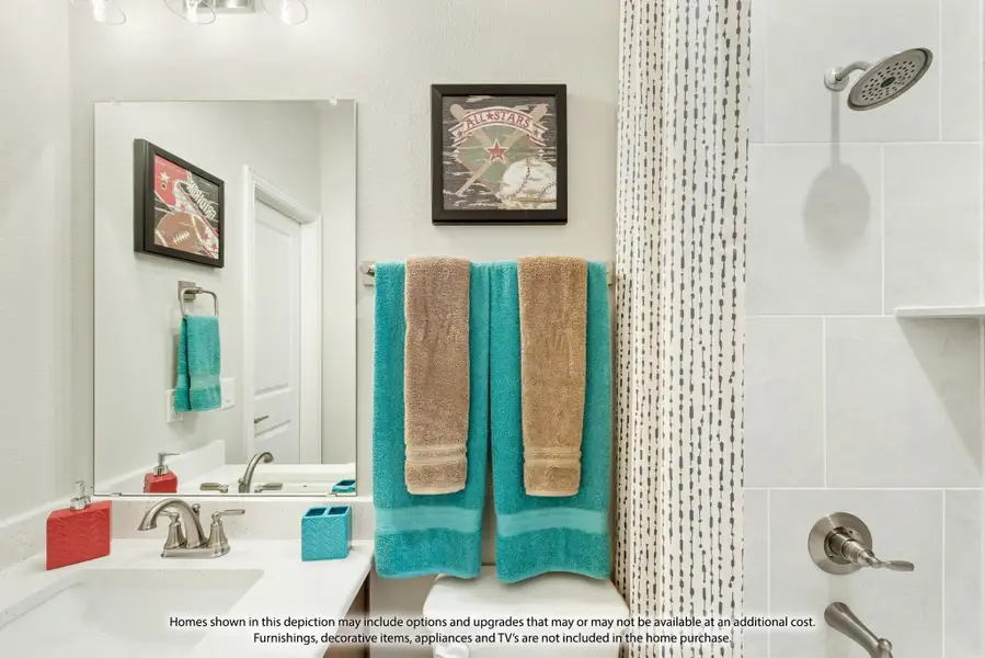 Bright kids' bathroom with white vanity, tiled shower, and teal towels on rack Bright kids' bathroom with white vanity, tiled shower, and teal towels on rack