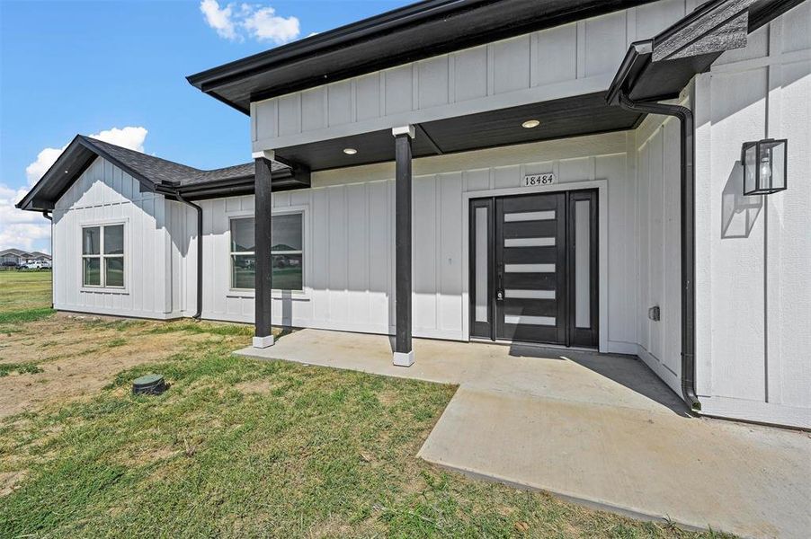 Entrance to property featuring a yard and a patio