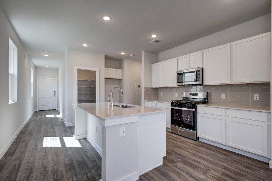 A kitchen with white cabinets.