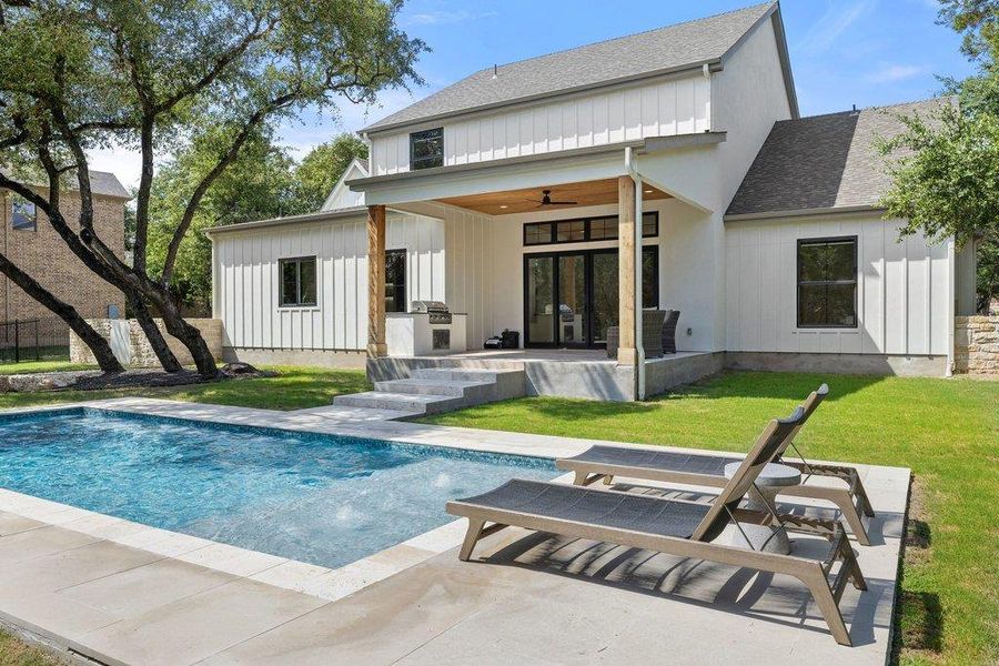 An inviting backyard oasis offers a sparkling pool, generous patio, and a covered outdoor kitchen. An inviting backyard oasis offers a sparkling pool, generous patio, and a covered outdoor kitchen.