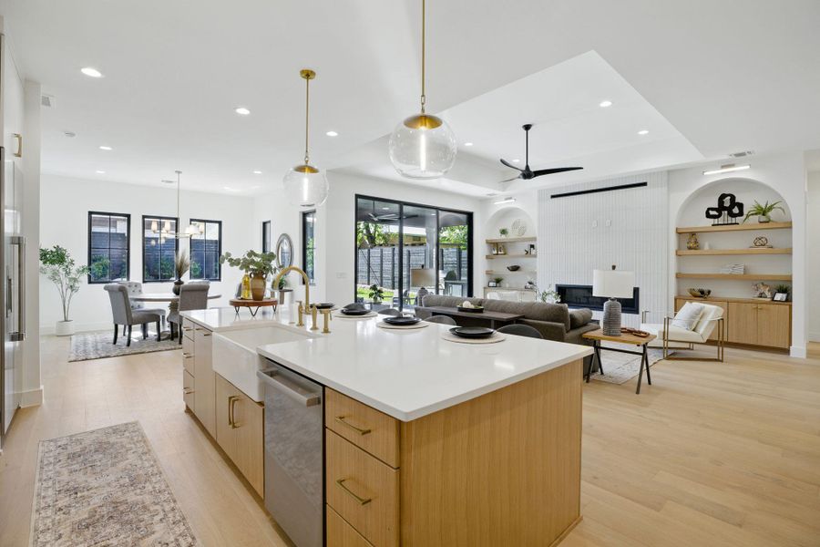 Kitchen featuring a sink, dishwasher, a ceiling fan, modern cabinets, and light wood finished floors