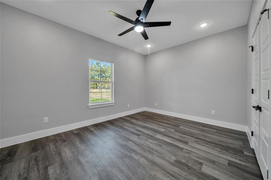 Unfurnished bedroom with dark wood-type flooring and ceiling fan